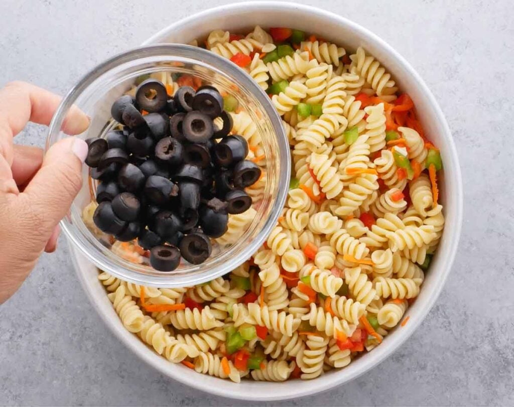 Italian Pasta Salad in a serving bowl with black olives on the side