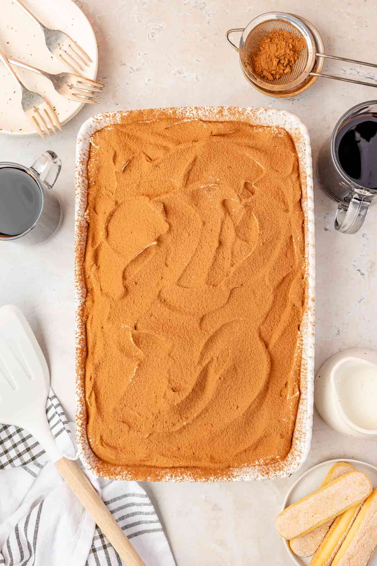 Tiramisu Poke Cake topped with cocoa powder
